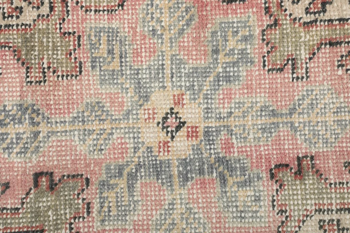 Extreme close-up of the rug's low wool pile and hand-knotted texture.