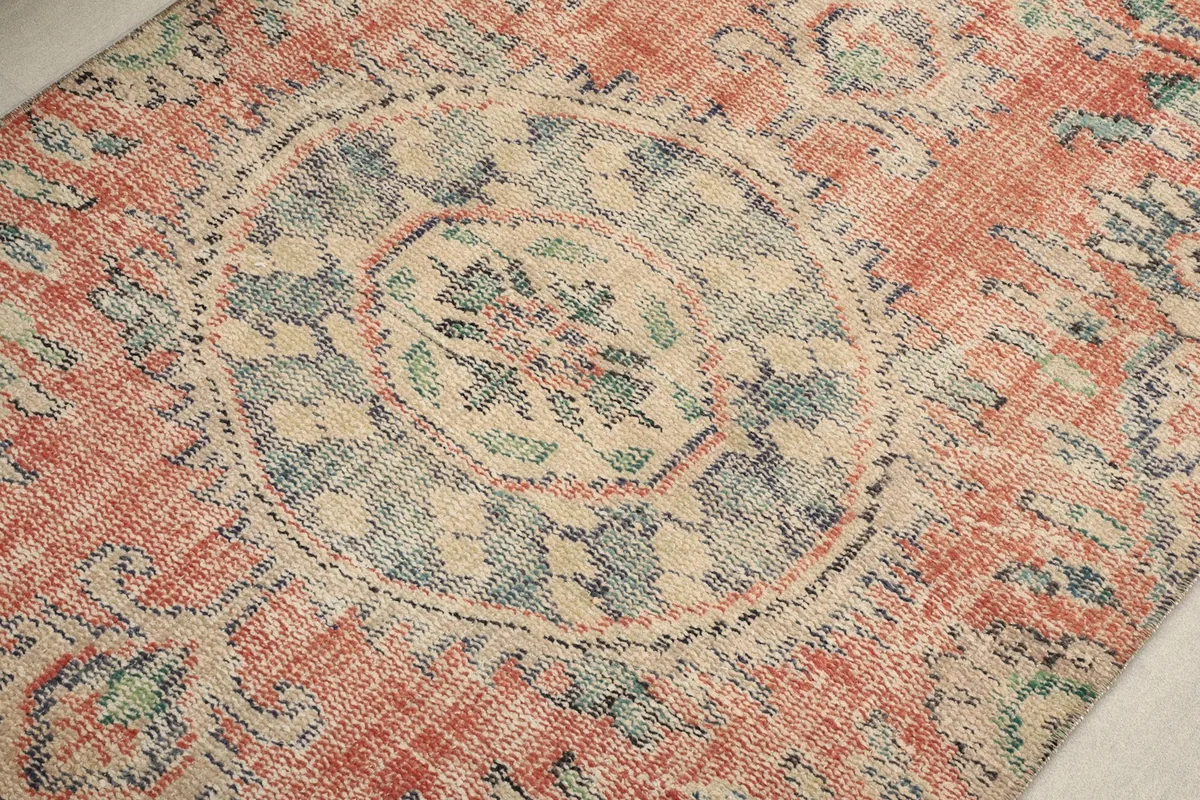 Close-up of the central medallion motif with blue, beige, and green patterns