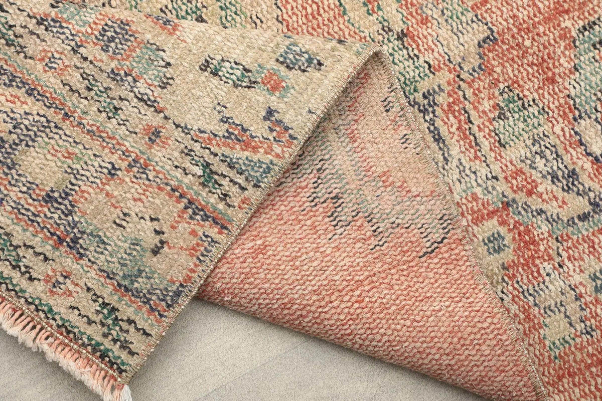 Another view of the folded rug, showing the back and the texture of the cotton foundation