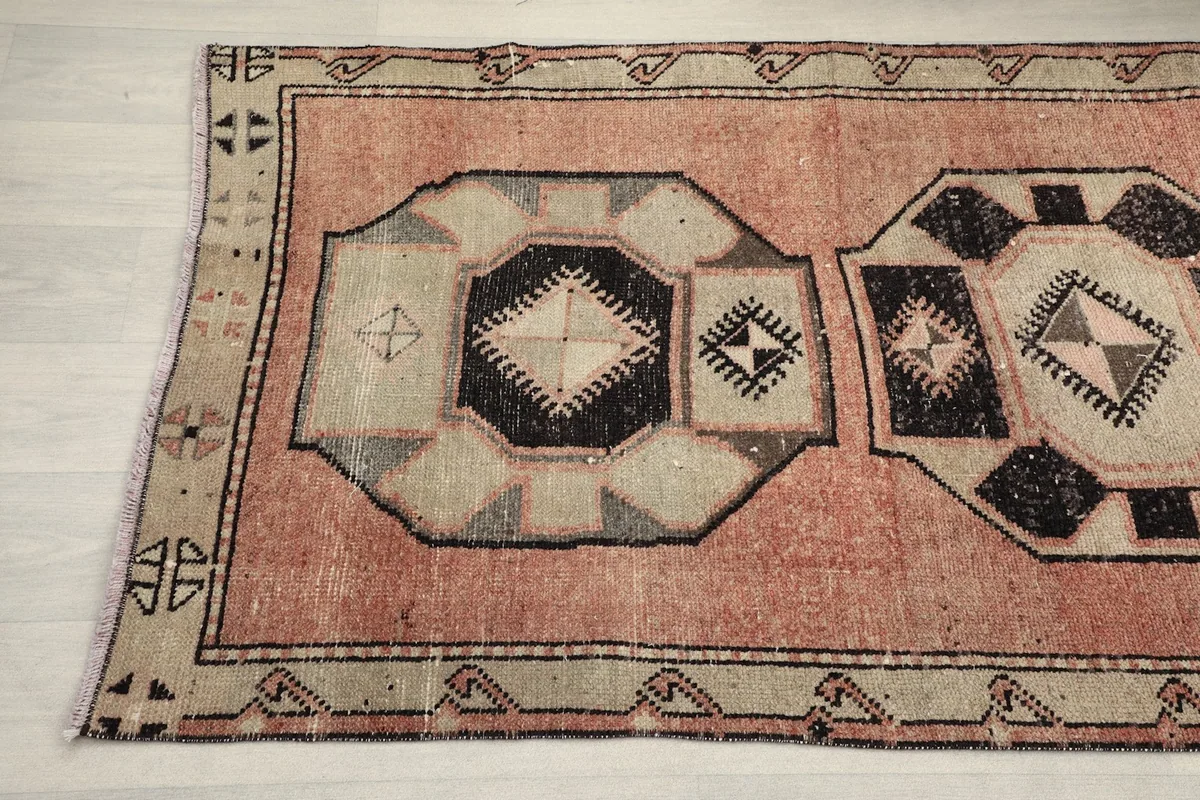 Close-up of the other end of the runner rug, highlighting the beige border and field