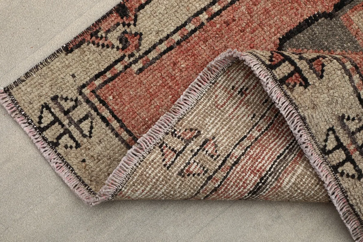 Corner of the rug folded back to show the back of the hand-knotted wool pile