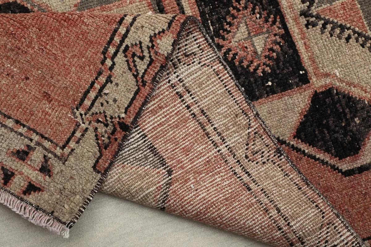 Side of the runner rug folded to reveal the cotton foundation and hand-knotted structure