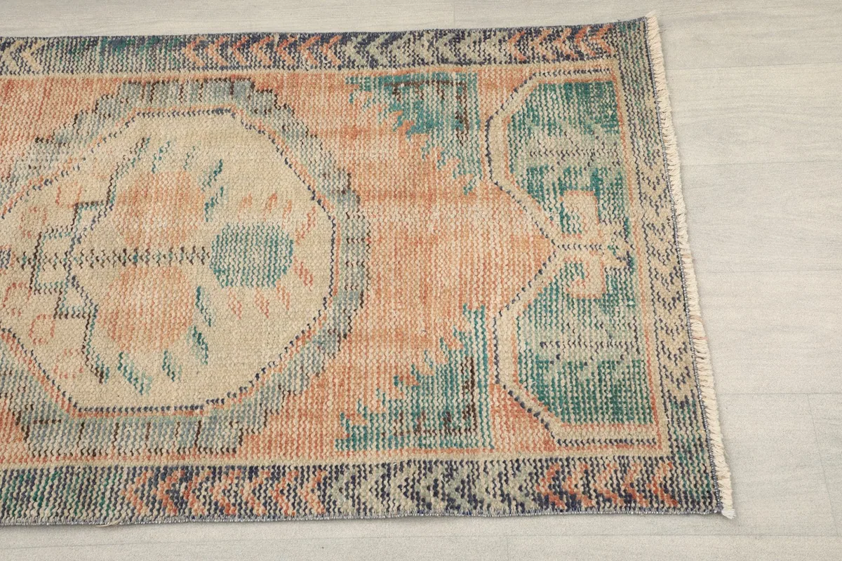 Close-up of the upper right section of the rug showing geometric patterns and border