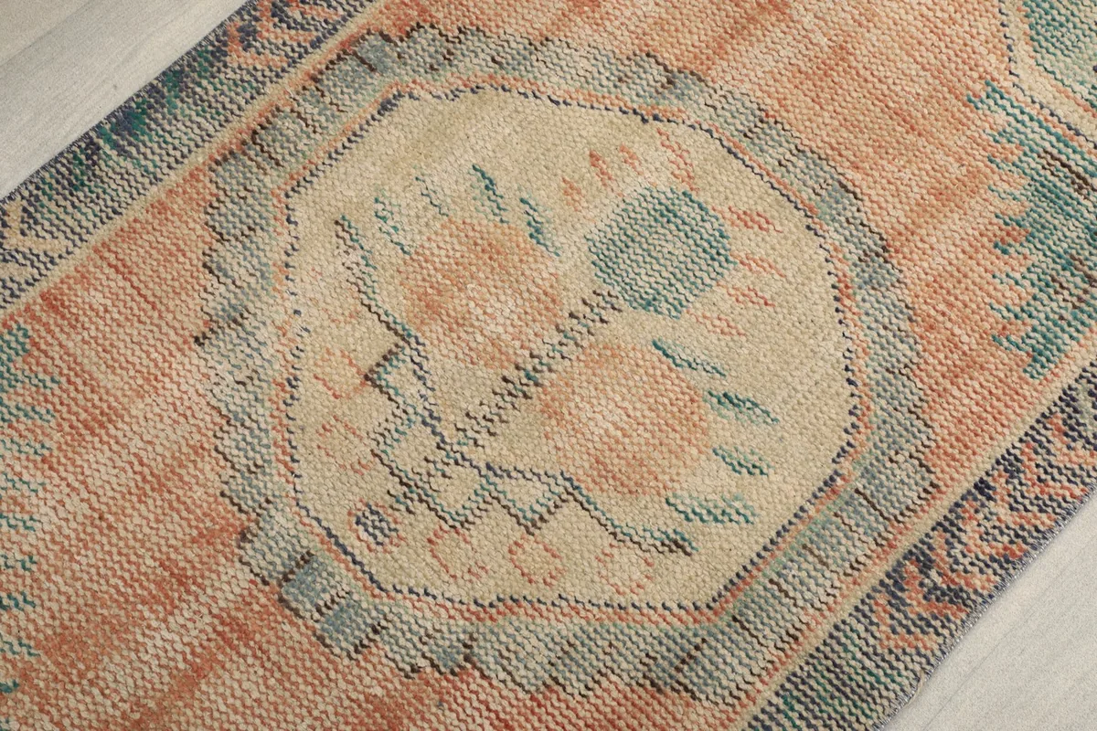 Detailed view of the central beige medallion with orange and green motifs