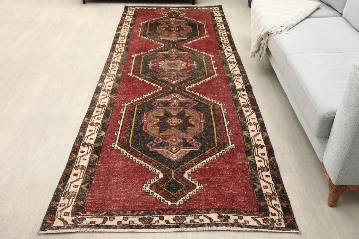 Full view of the rust runner in a room setting, next to a light gray sofa
