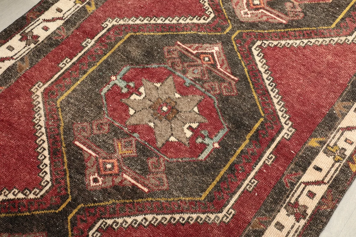Detailed view of a central geometric medallion with rust, black, and beige tones