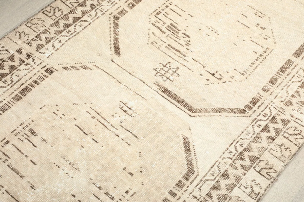 Overhead close-up of the central geometric motifs and border design of the rug