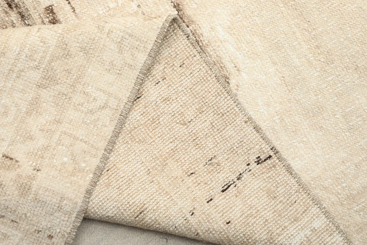 Underside view of the rug, revealing the cotton foundation and knotting