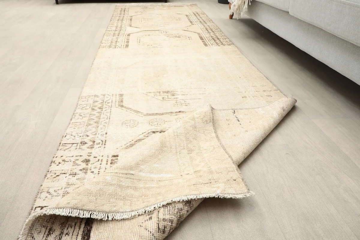 Runner rug partially unrolled on the floor, showcasing its length and pattern flow