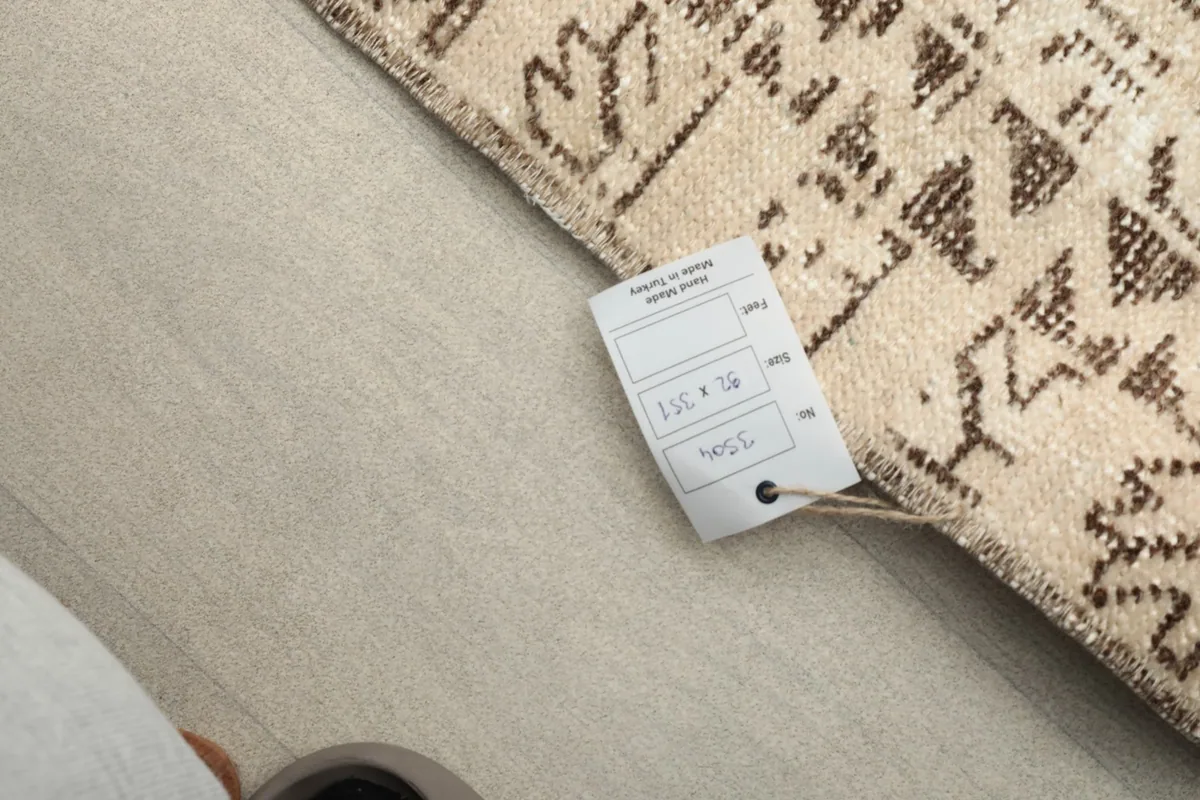 Label attached to the rug's corner, displaying its size and origin details