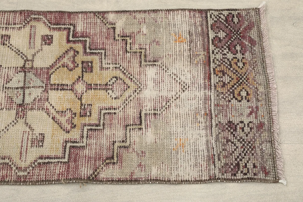 Close-up of one end of the runner, showing the rose, beige, and tan colors and tribal motifs