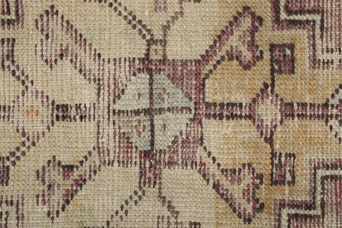 Macro shot of the low wool pile, revealing the hand-knotted texture and color variations