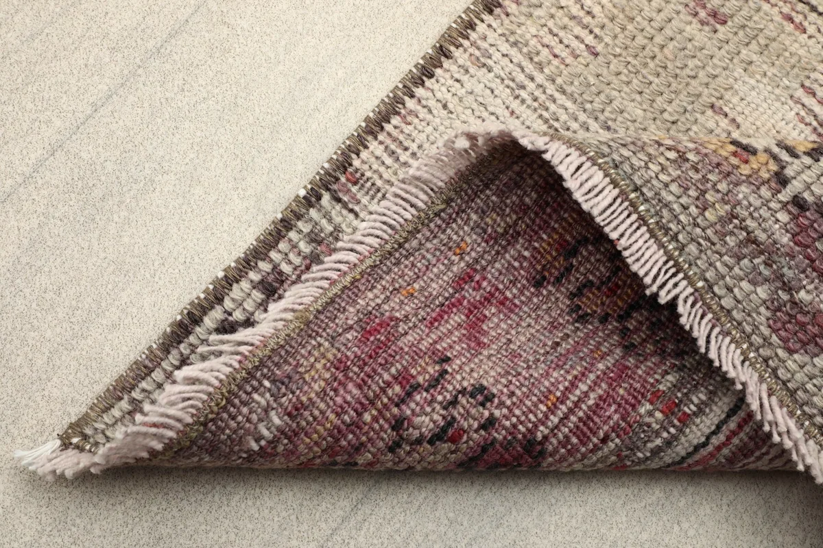 View of the back of the rug, showing the cotton foundation and hand-knotting