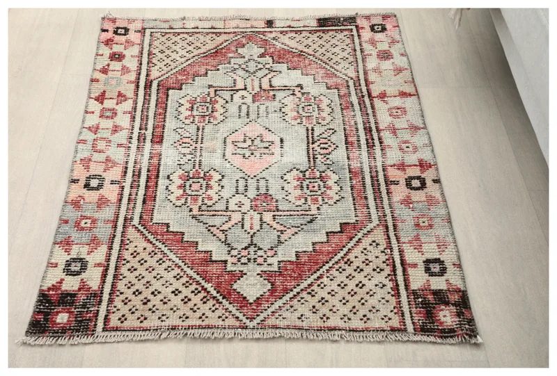 Full top view of the gray and rose geometric hand-knotted vintage rug.
