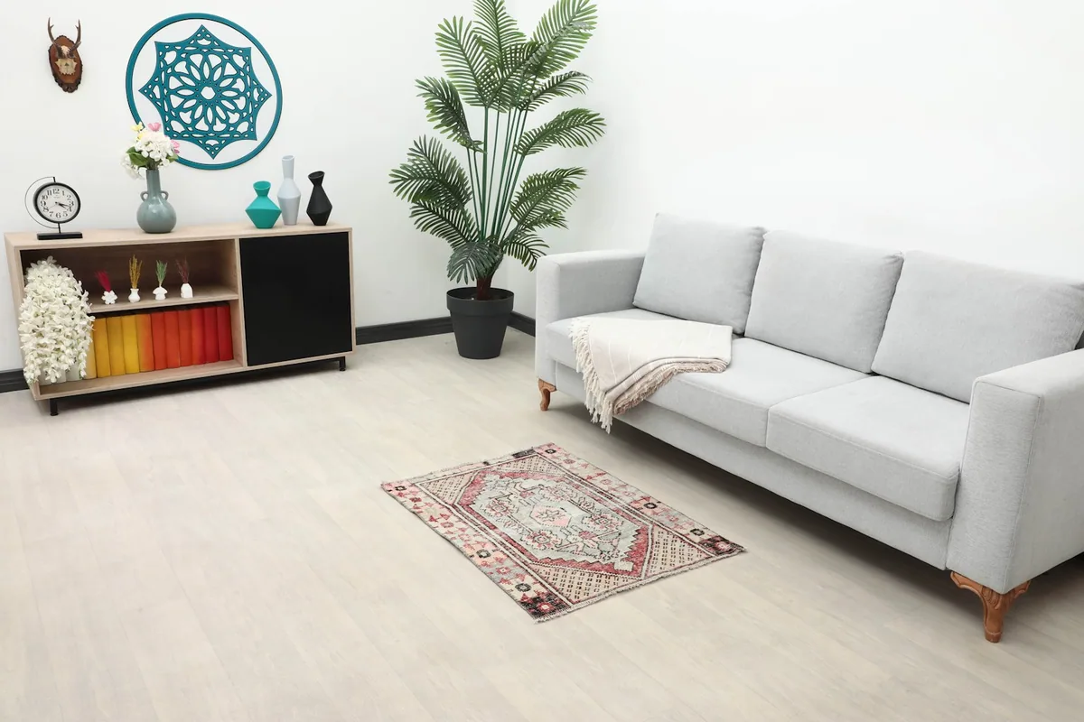Overhead view of the rug placed in a living room setting next to a gray couch.