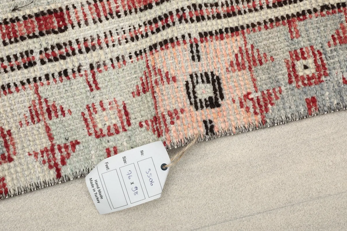 Close-up of the rug's corner with a tag indicating its size and origin.