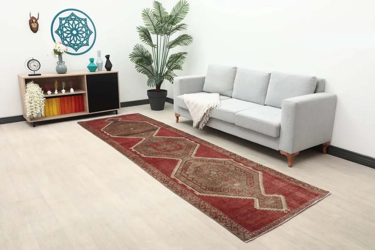 Long view of the red runner rug in a room with a sofa and side cabinet