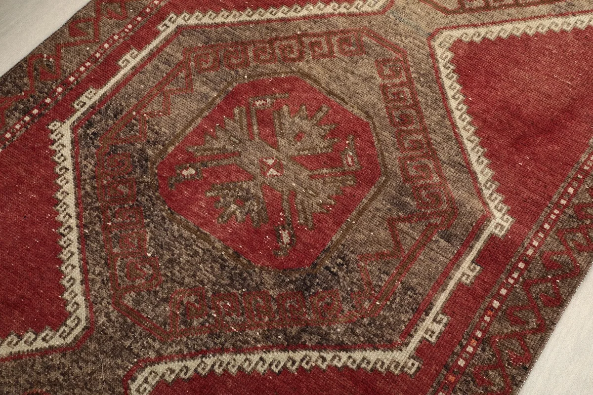 Close-up of a tribal medallion with red and brown tones on the vintage runner