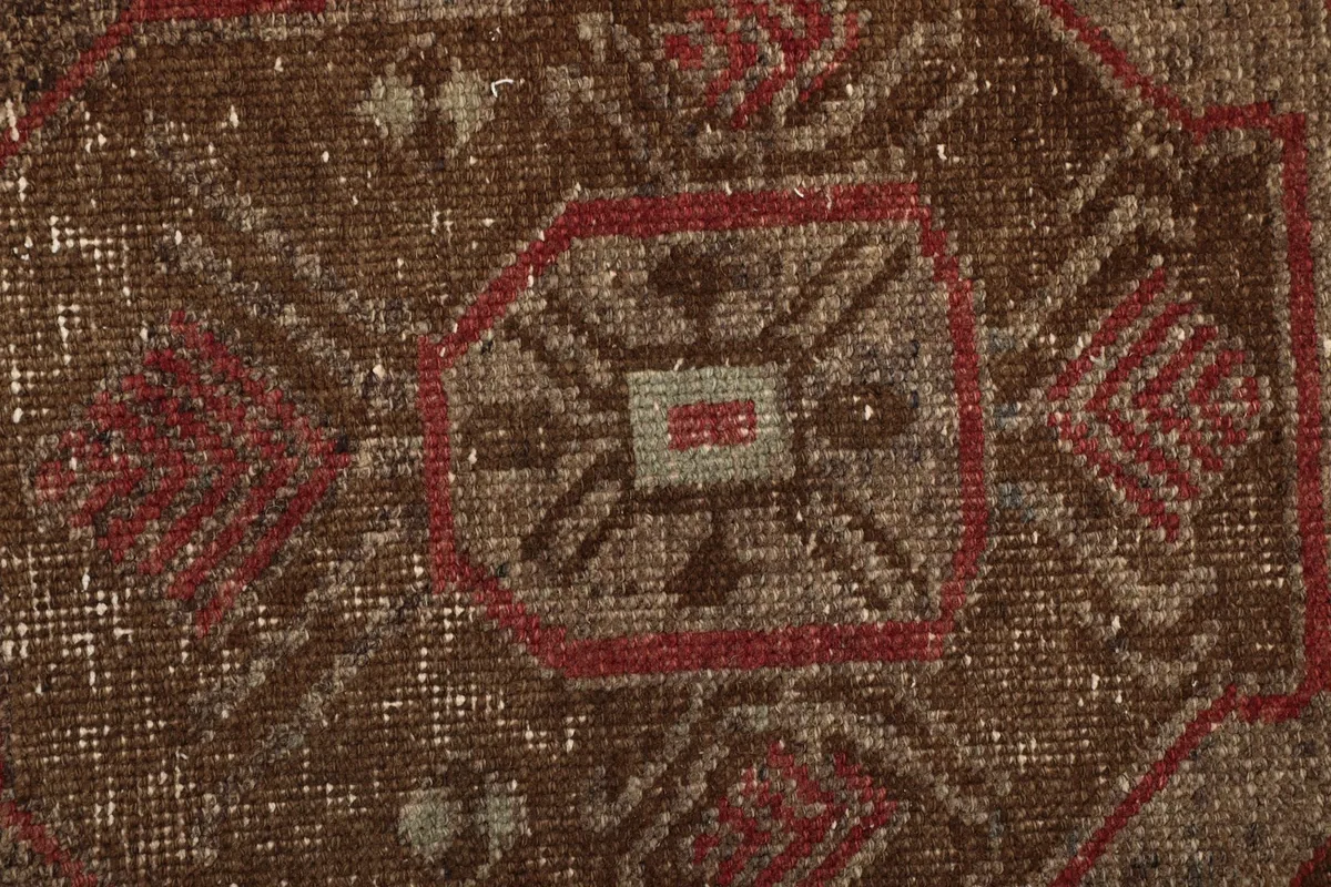 Extreme close-up showing the low wool pile and hand-knotted texture of the rug