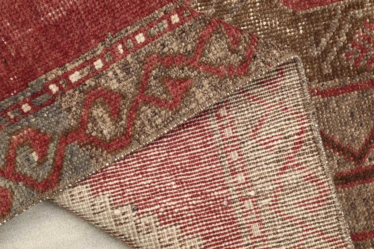 View of the back of the rug, showcasing the hand-knotted construction and fringe