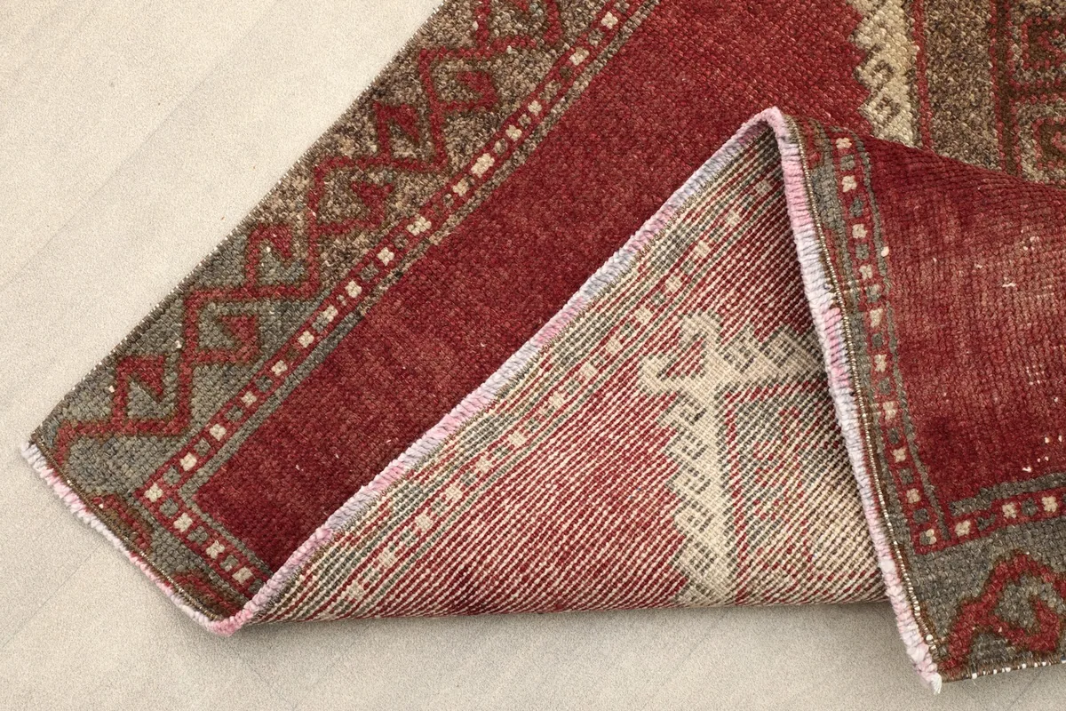 Folded corner of the rug revealing the cotton foundation and reverse side