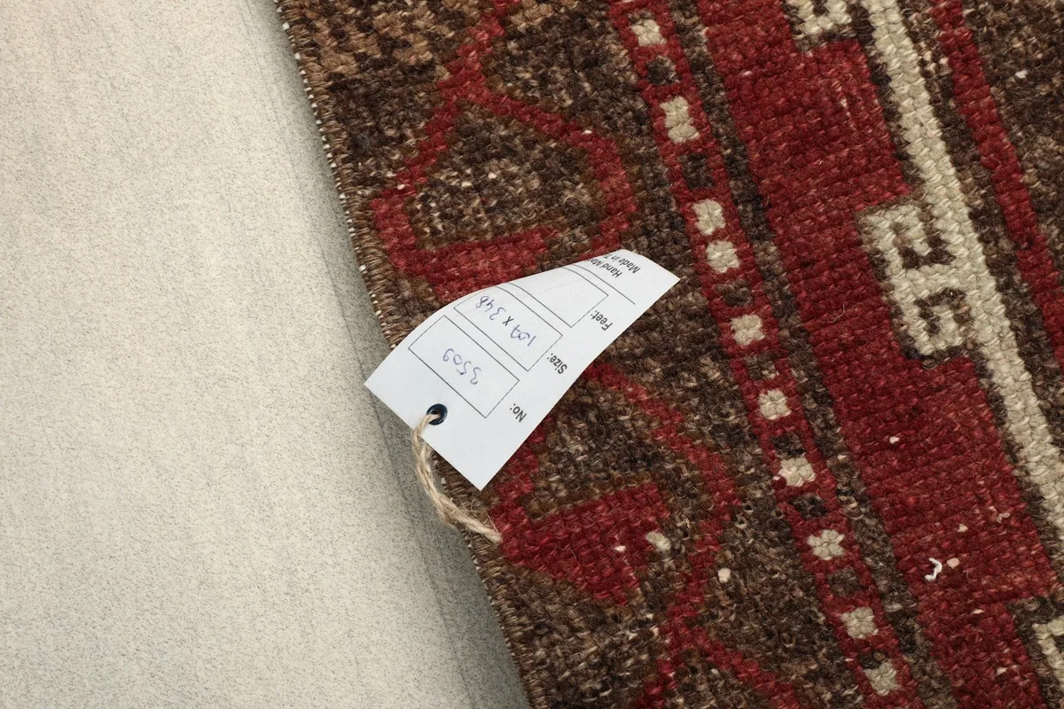 Detail of the rug's label with size information, next to the geometric border