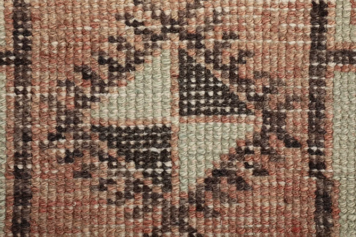 Close-up of the hand-knotted wool pile texture and distressed areas