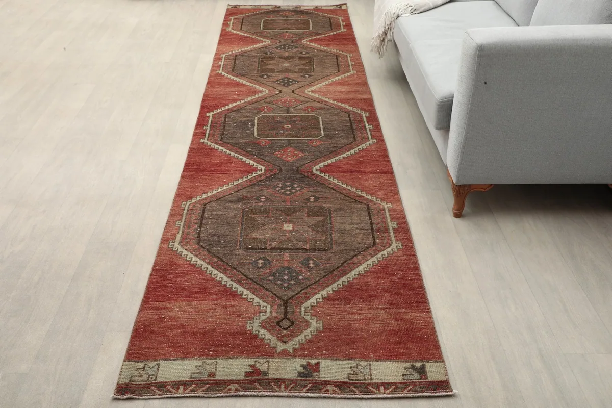 Vintage runner rug in a modern living space, showing its length next to a sofa