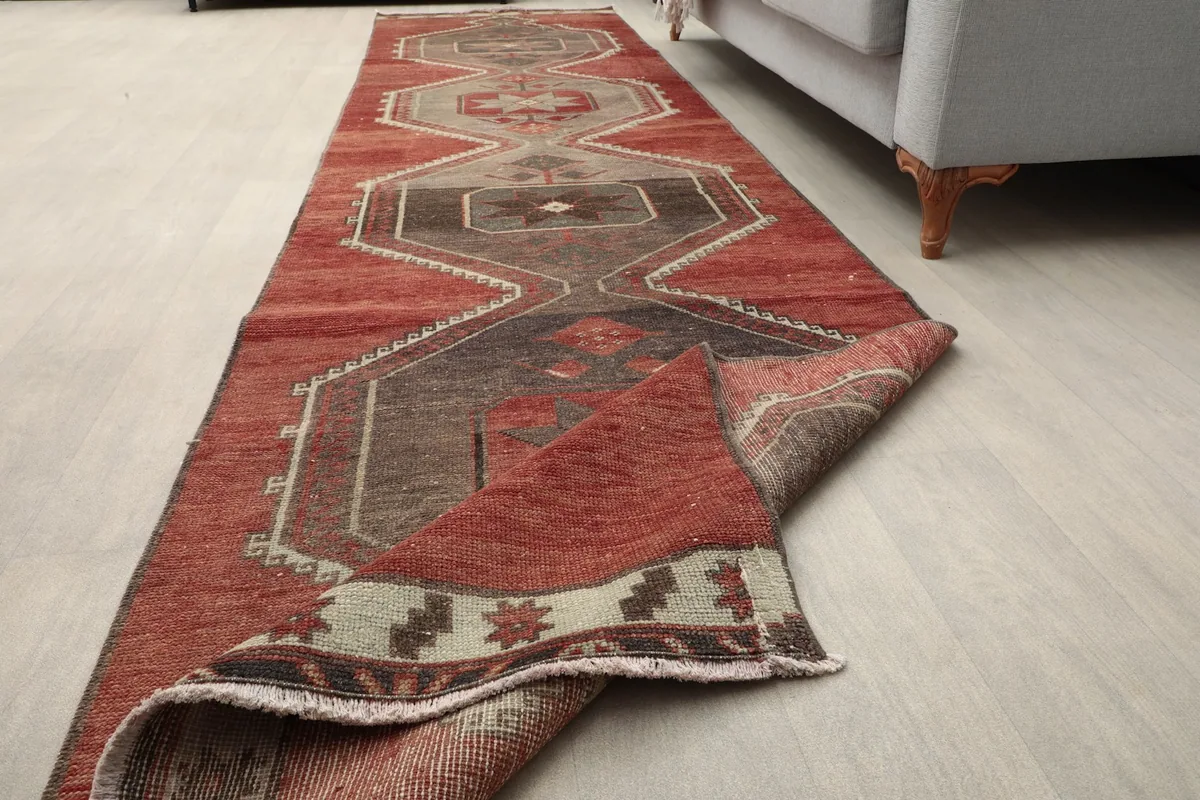 Runner rug partially folded, illustrating its flexibility and the texture of the low wool pile.