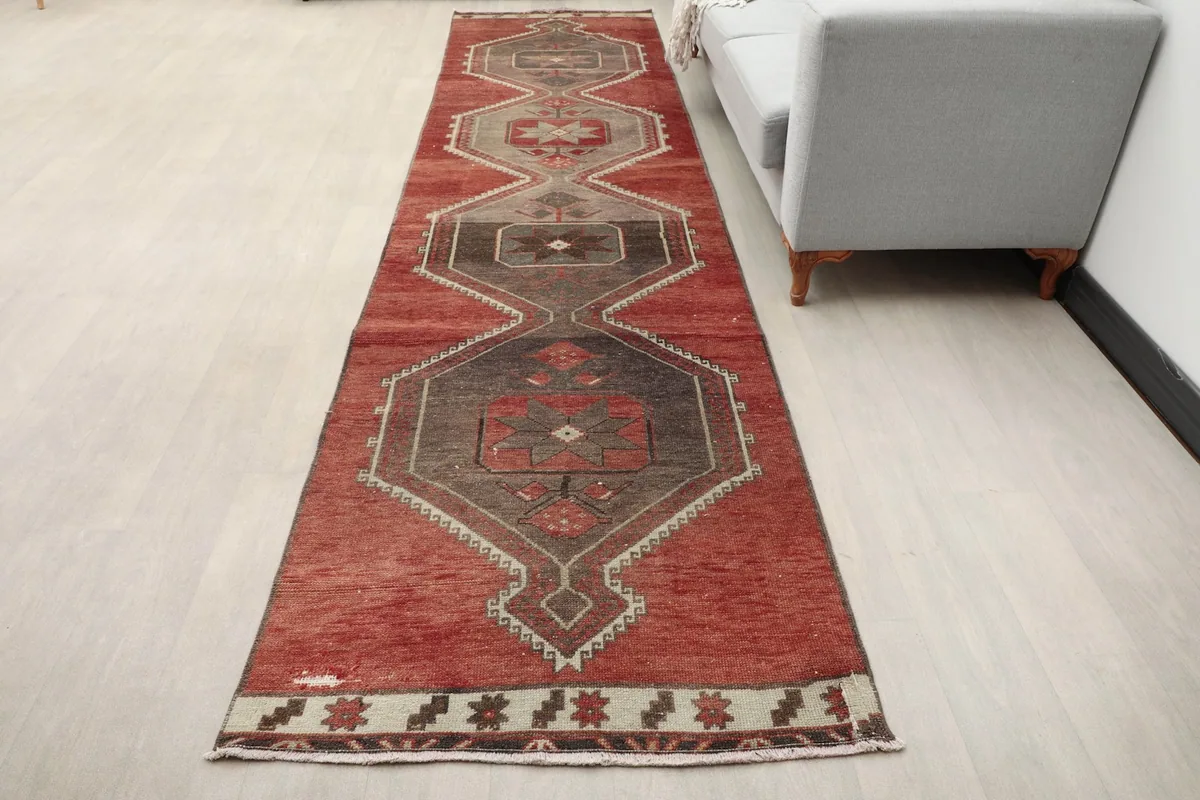 Overhead view of the red and gray runner rug placed on a light floor, showing its full length.