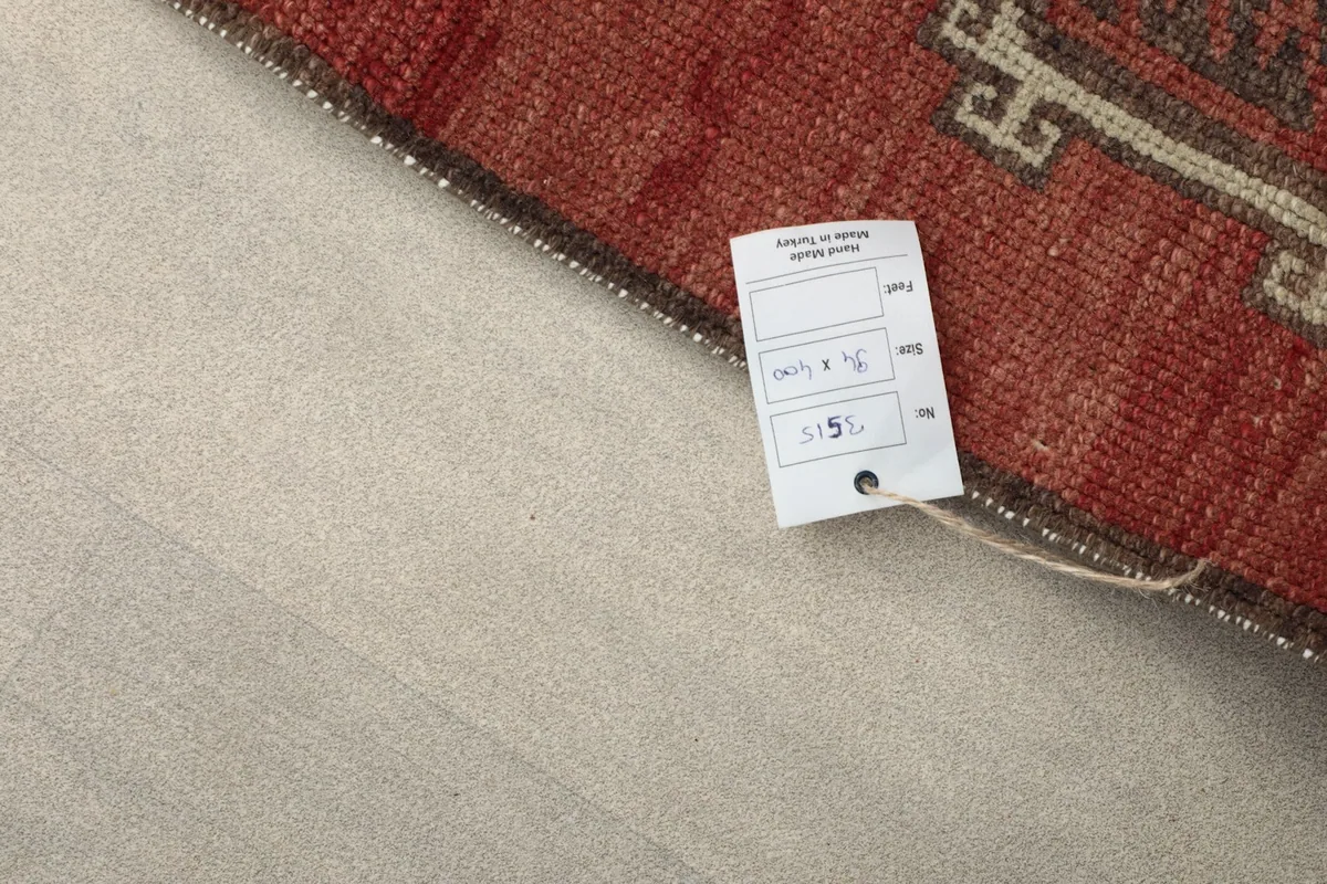 Corner of the runner rug with a product tag, showing the origin and dimensions details.