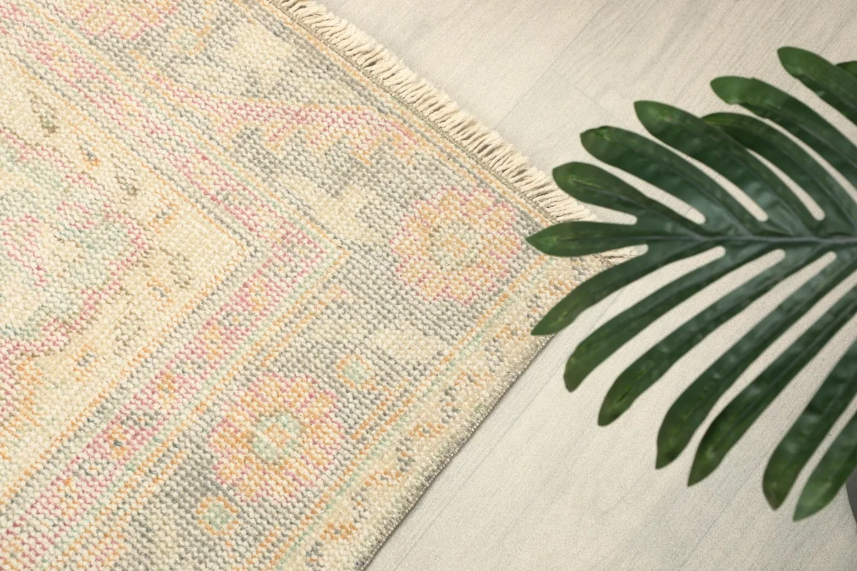 Close-up of the rug's border and edge, showing the texture and faded color palette