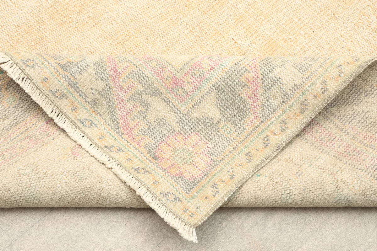 View of the rug's underside and folded corner, revealing the cotton foundation