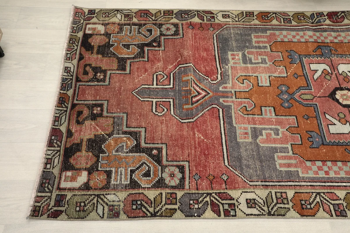 Detail of the rug's border and field, capturing the hand-knotted texture and tribal designs