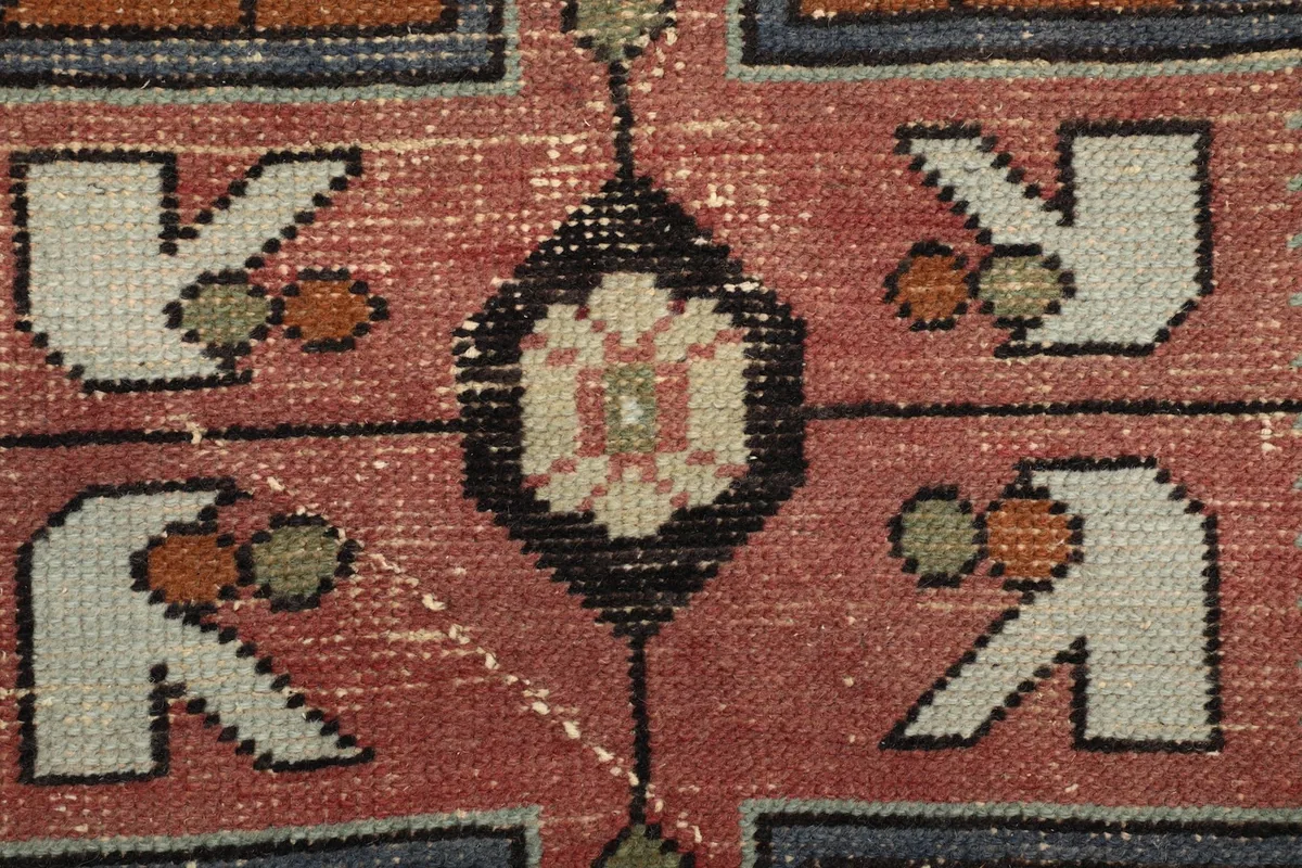 Extreme close-up of the rug's low wool pile, showing individual knots and color blend