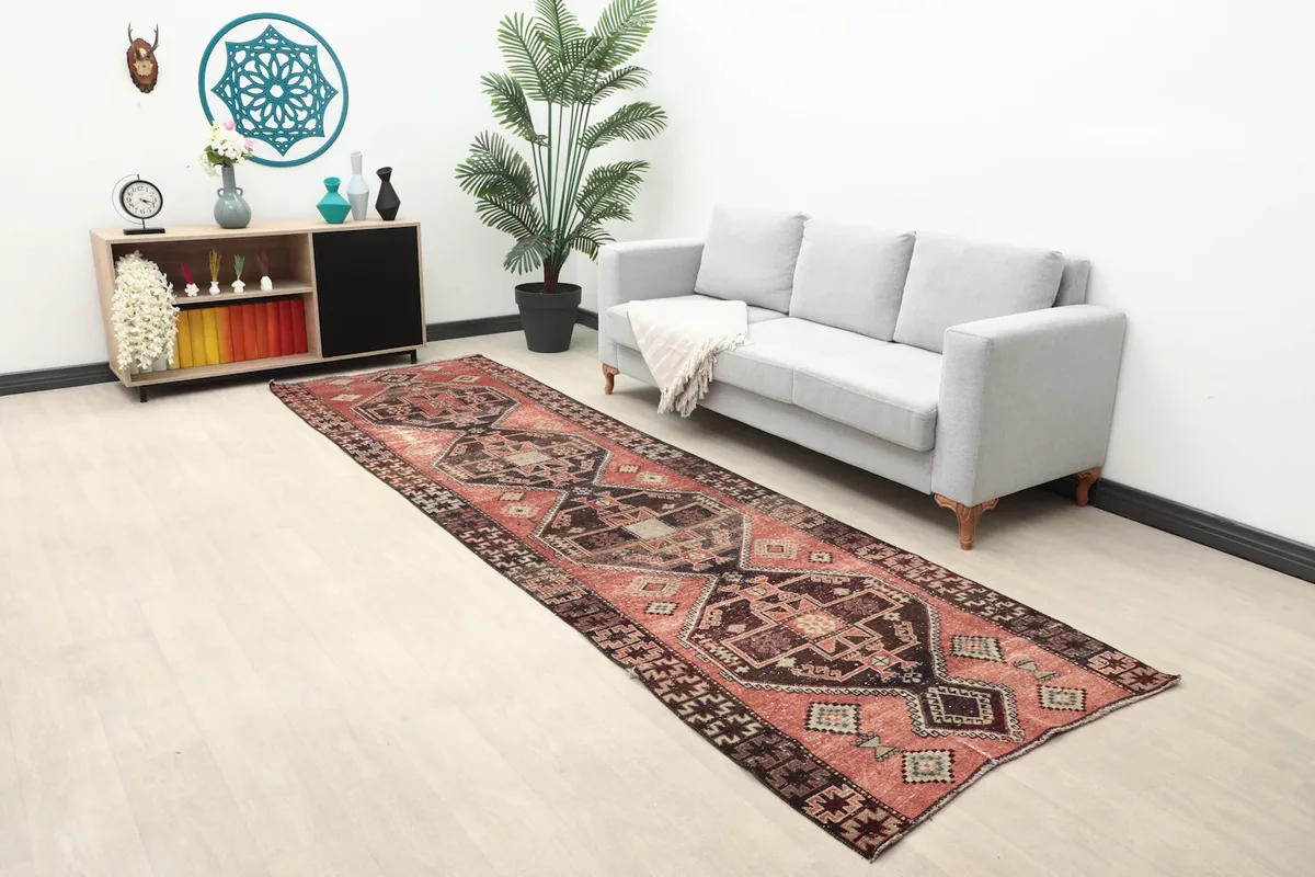 Overhead angle of the rust geometric runner rug in a bright room setting with a sofa and plant
