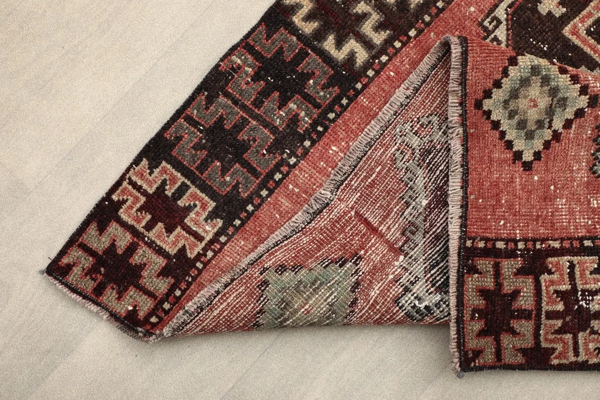 View of the rug folded back, showing the back of the rug and cotton foundation