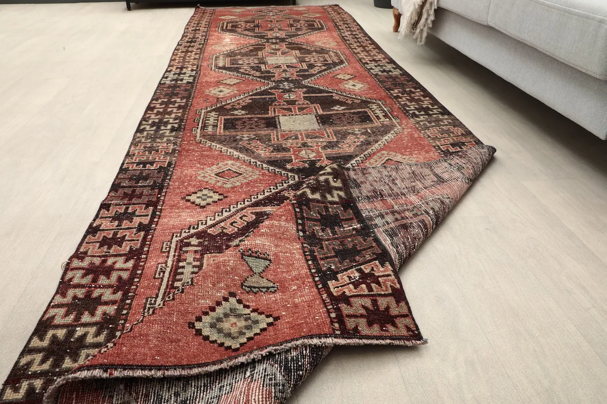 Angled view of the runner rug with one end folded, showing the full pattern and texture