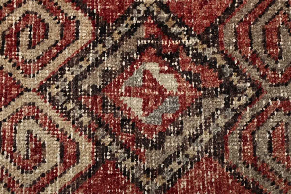 Macro shot of a central geometric motif, showing the intricate knotting and color blending