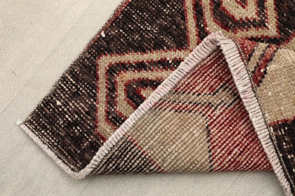 Corner of the rug folded to show the cotton foundation and reverse side of the hand-knotted construction