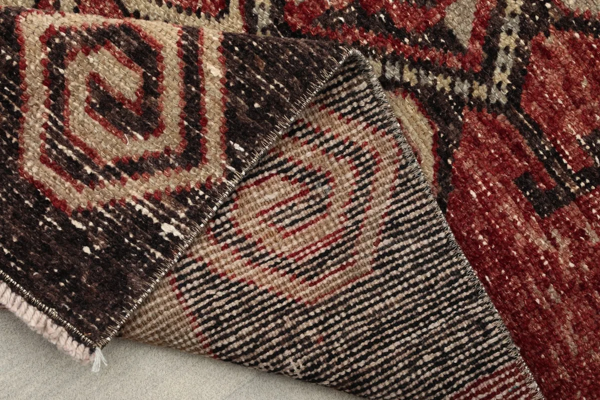 Close-up of the rug's back, revealing the tight knotting and wool fibers on cotton foundation