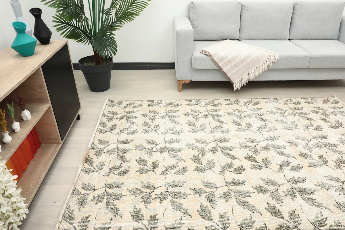 Angled view of the rug in a room, showing its scale next to a sofa and cabinet