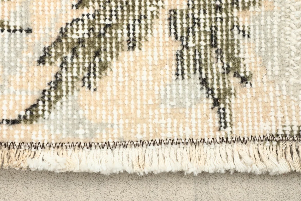 Close-up detail of the fringe and edge of the hand-knotted wool rug