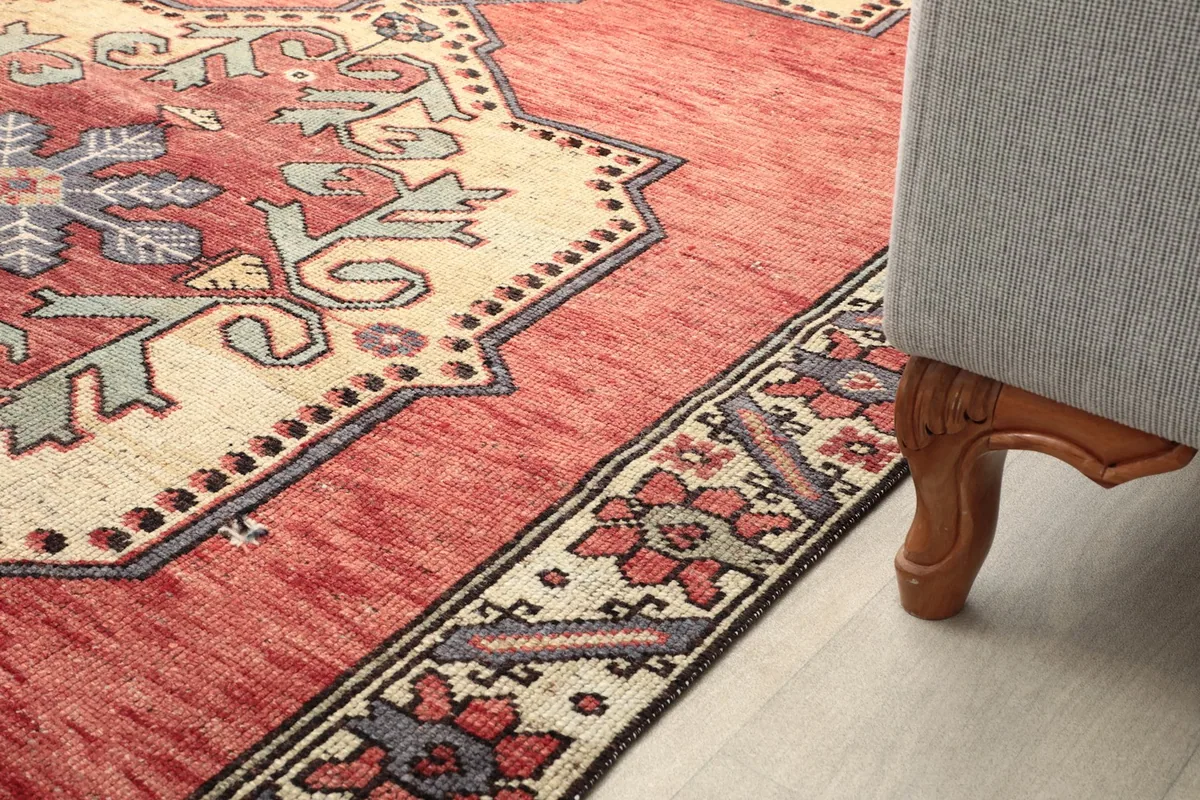 Detail of the rug's pattern next to a furniture leg, illustrating its scale and how it fits with home decor.