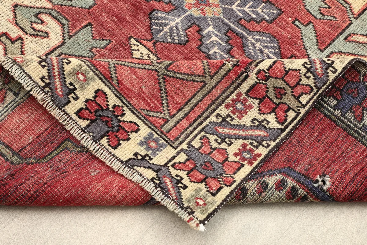 Rug corner folded over, revealing the cotton foundation and the reverse side of the hand-knotted construction.