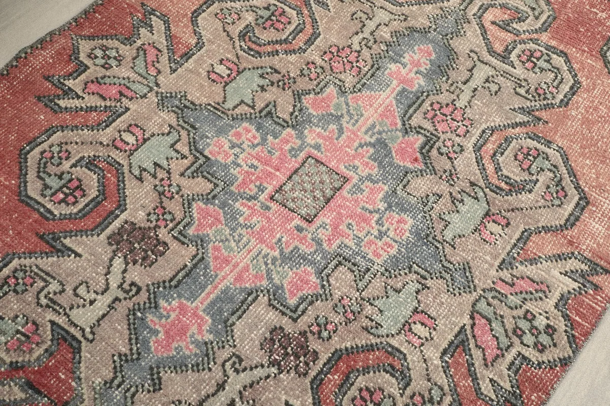 Detailed close-up of the central medallion with pink and gray geometric designs