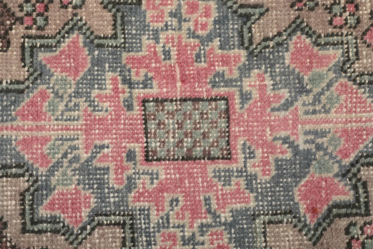 Very close detail of the hand-knotted wool pile and the intricate central pattern