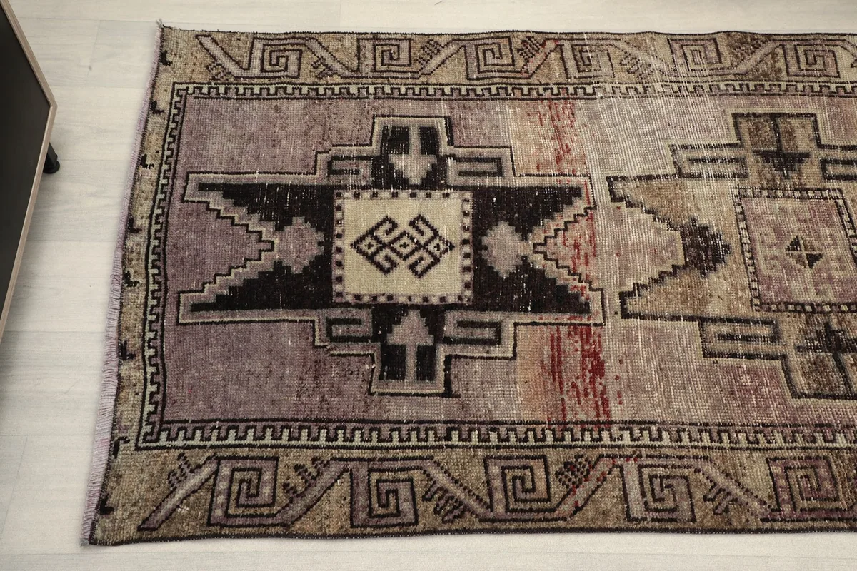 Angled view of the middle section of the runner, featuring a prominent charcoal tribal design and color variation.