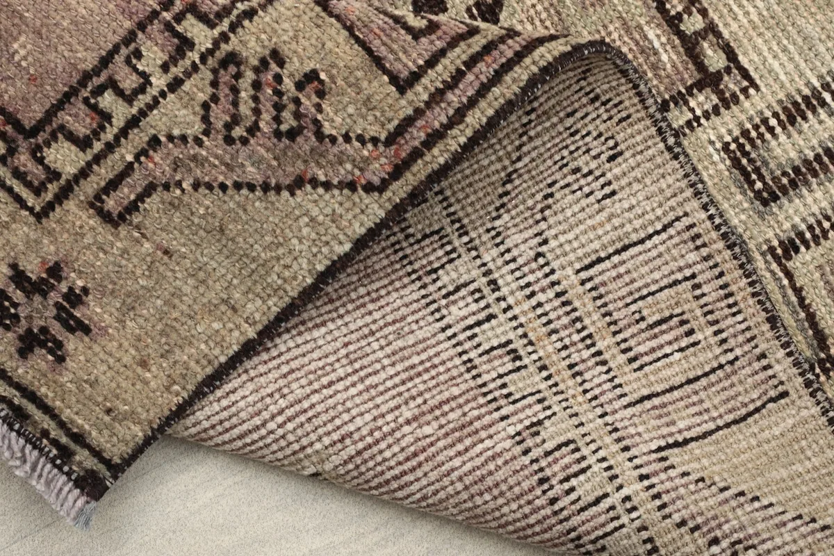 Folded view demonstrating the rug's construction, showing the back of the hand-knotted wool pile on cotton.