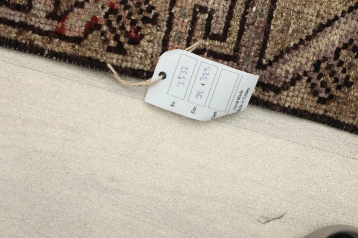 Close-up of the rug's label, confirming the size 95 x 325 cm and hand-knotted origin.